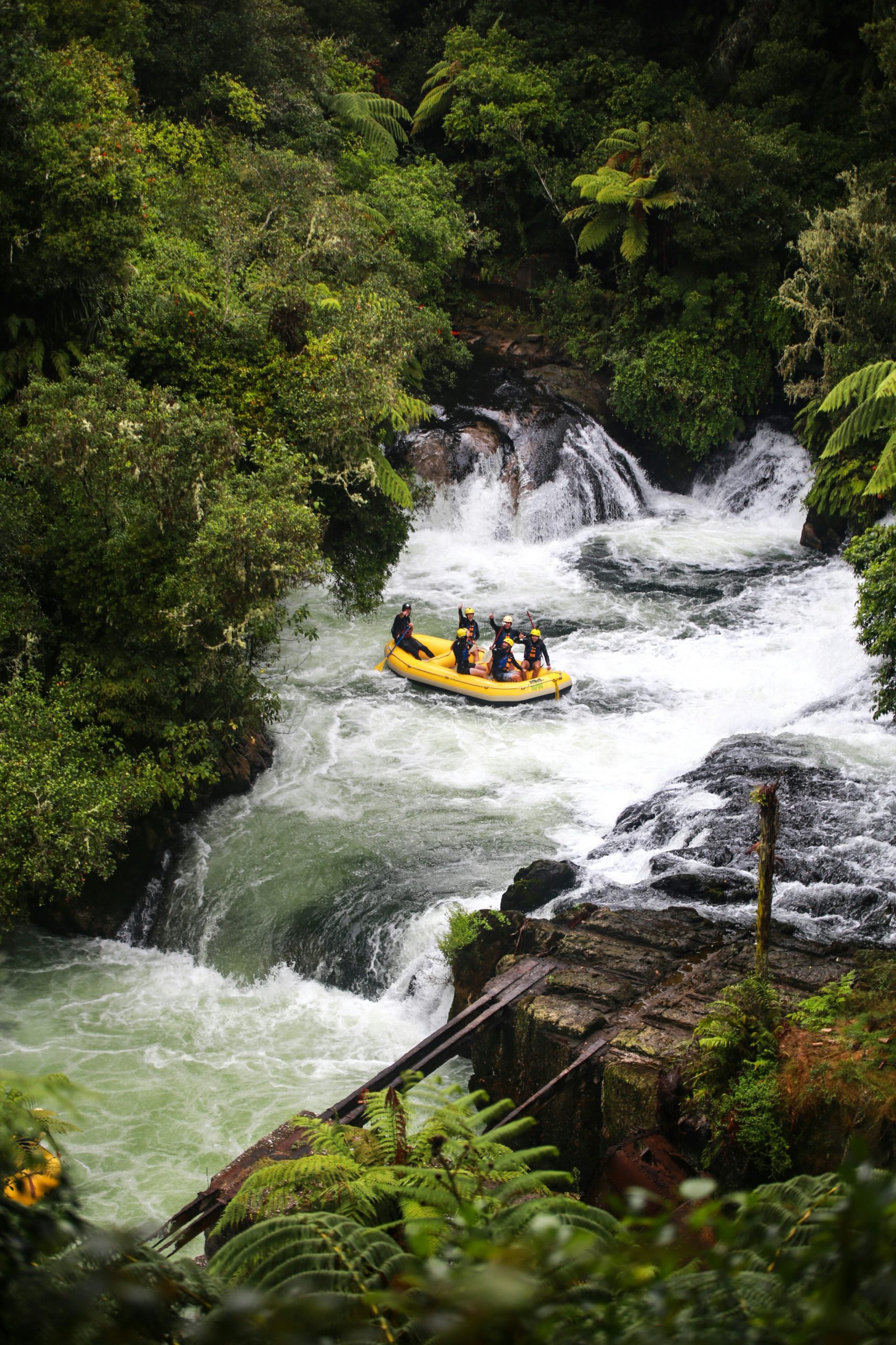 Whitewater raft passing through a narrow river gorge.